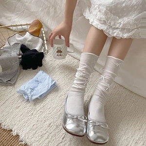 Detail of sweet ballet-style mesh socks with ribbon bows in white, grey, black and blue