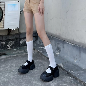 Detail of black platform Mary Jane shoes with patent leather and silver metal buckles