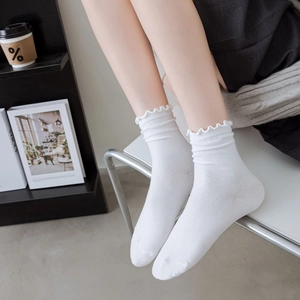 Detailed view of white cotton socks with lettuce edge ruffle and ribbed knit texture