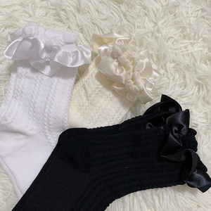 Détail de chaussettes mi-bas Lolita avec volants en satin et texture de maille torsadée