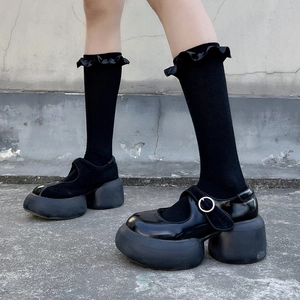 Detail of Lolita style ruffled socks paired with black platform Mary Jane buckled shoes