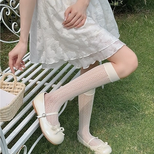 Detailed close-up of white floral lace knee-high socks paired with cream Mary Jane shoes