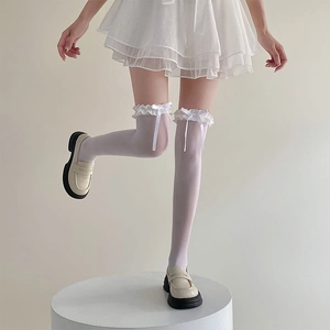 Gros plan de chaussettes hautes blanches avec volants en dentelle et nœuds rubans