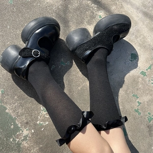 Detail of black Mary Jane shoes with ribbon lace socks in Gothic Lolita style