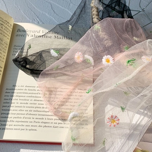 Close-up of sheer mesh socks with daisy embroidery in black, pink, and white