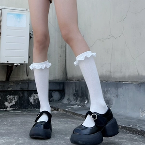 Close-up of white Lolita lace frill socks styled with black platform Mary Jane shoes