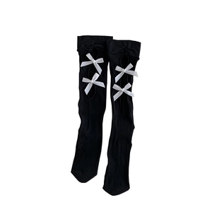 Lolita style black knee-high socks with hollow cutouts and white satin bows