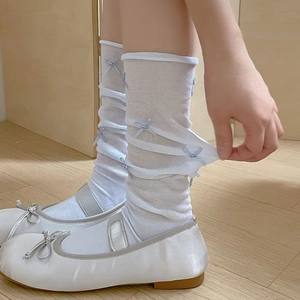 Detail of light blue mesh socks with bows showing elastic texture and ballet shoes