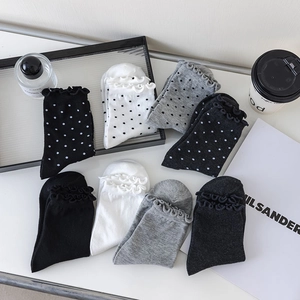 Detailed flat lay of cotton crew socks featuring ruffled lettuce trim and polka dot patterns