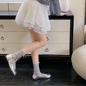 Detailed view of silver mirror Mary Jane shoes with grey knit socks and sweet ballet style