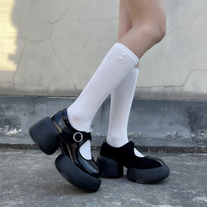 Platform Mary Jane shoes in glossy black leather paired with white pearl socks