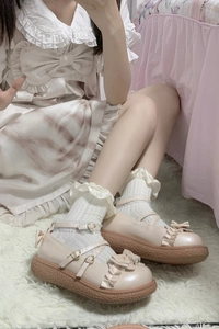 Détail de chaussures compensées roses avec nœuds et chaussettes en dentelle sur tapis