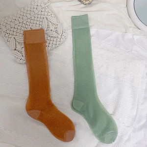 Japanese style ginger and green calf socks in a cozy knit texture on white fabric