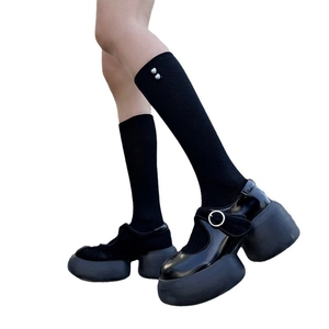 Black platform Mary Jane shoes with glossy patent finish and heart-embellished socks
