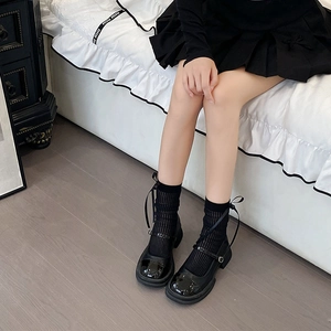 Detail of black Mary Jane shoes with ribbon bow socks in ballet core style