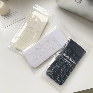 Three-pack of hollow knit knee-high socks in beige, white, and black with floral patterns