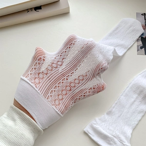 Detail of white lace mesh stocking showing elastic floral texture and hollow mesh design