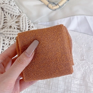 Detail of orange-brown metallic glitter mesh fabric with fine knitted texture