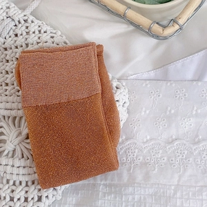 Detail of caramel shimmering calf socks with fine lurex texture on lace fabric