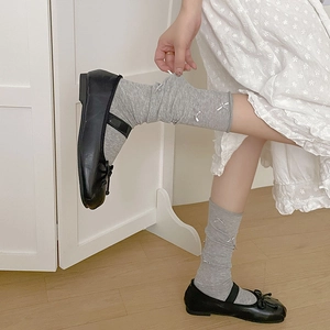 Detail of grey ballet style socks with small silver bows and mesh texture on legs