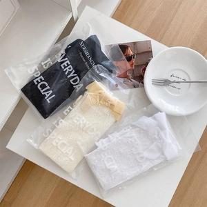 Detailansicht von dreifarbigen Ballet-Spitzensocken mit Samtschleifen in Geschenkverpackung