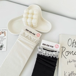 Detail of lace trim and pearl beads on sweet Japanese style mesh socks in black and white