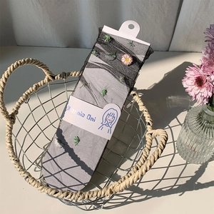 Sheer mesh crew socks for women featuring elegant daisy embroidery in grey mesh fabric