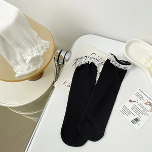 Detailed view of lace edge socks with pearl accents in black and white styles