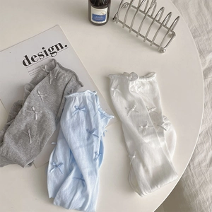 Detailed view of breathable mesh knit socks with delicate ribbon bow accents and wavy edges