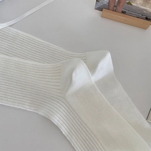 Detailed close-up of white ribbed knit socks showing high-quality texture and fabric