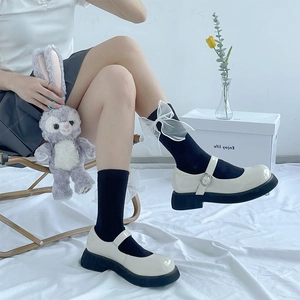 Détail de chaussettes noires Lolita avec grand nœud blanc en organza et style doux