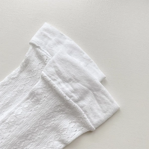 Detail view of white lace calf socks featuring delicate hollow patterns and elastic cuffs