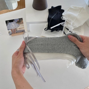 Detailed macro shot of elastic ribbed socks with elegant ribbon bows in various colors