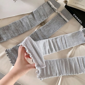 Detail of knit leg warmers with vertical stripes and delicate ribbon bow accents