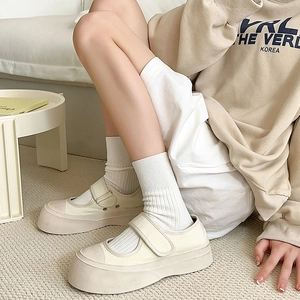 Detail of cream platform Mary Jane canvas shoes with velcro strap and white ribbed socks