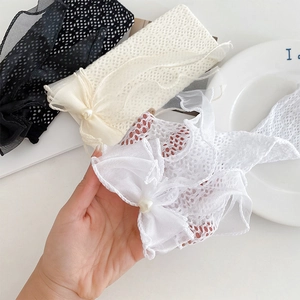 Détail de chaussettes en dentelle avec volants en maille, perles et nœuds élégants