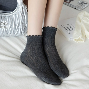 Detail of dark grey hollow pointelle mesh socks with elegant scalloped lace edges