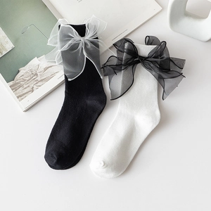 Détail de chaussettes blanches en coton avec de grands nœuds en mesh sur les côtés