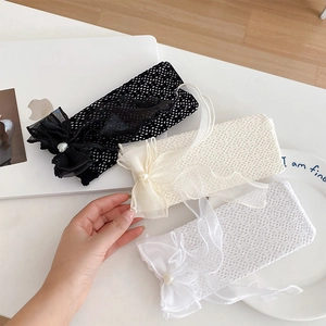 Détail de chaussettes en maille transparente avec nœuds en tulle et perles de couleur beige