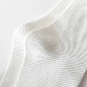 Gros plan détaillé de la texture tricotée blanche et des coutures des chaussettes