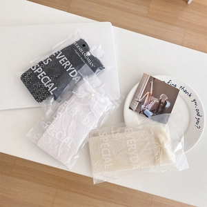 Vue détaillée de chaussettes en dentelle avec nœuds dans des sacs transparents