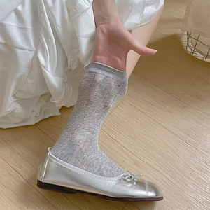 Gros plan de chaussettes mi-mollet grises avec rayures ajourées et broderies florales