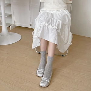 Gros plan de ballerines argentées avec nœud et chaussettes grises mi-hautes