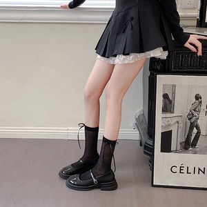 Detail of sheer striped socks with black ribbon bows paired with Mary Jane shoes