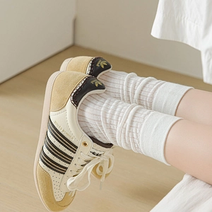 Detail of retro cream sneakers with black stripes and white vertical striped socks