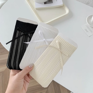 Détails de texture tricotée et nœuds sur chaussettes résille en noir, blanc et beige