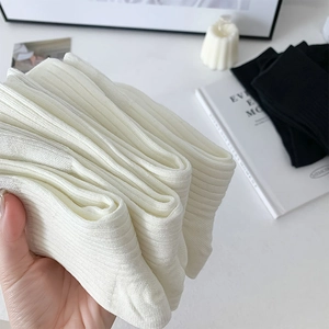 Detailed view of black and white ribbed crew socks with vertical stripe texture