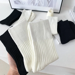 Close-up of ribbed texture on black and white cotton crew socks with minimalist design