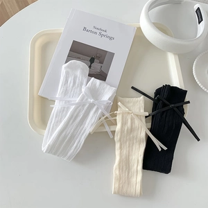 Gros plan sur la maille côtelée et les détails de nœuds en ruban des chaussettes