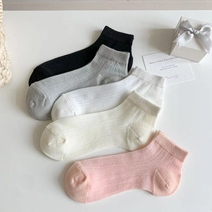 Détail de chaussettes en coton côtelé minimalistes en cinq couleurs pastel douces